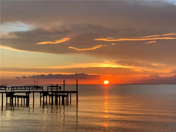 a dining room with furniture a chandelier and a floor to ceiling window