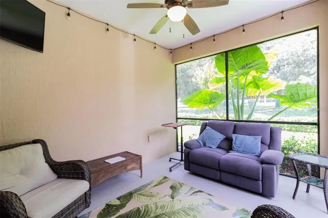 a living room with furniture a flat screen tv and a large window