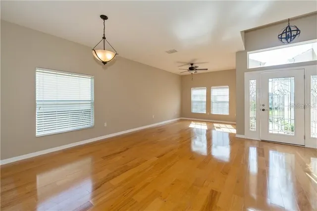 a view of an empty room with a window and wooden floor