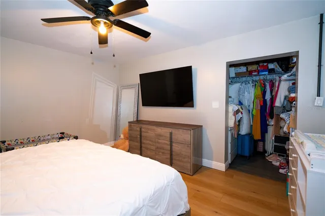 a bedroom with a bed and a flat tv screen on wall