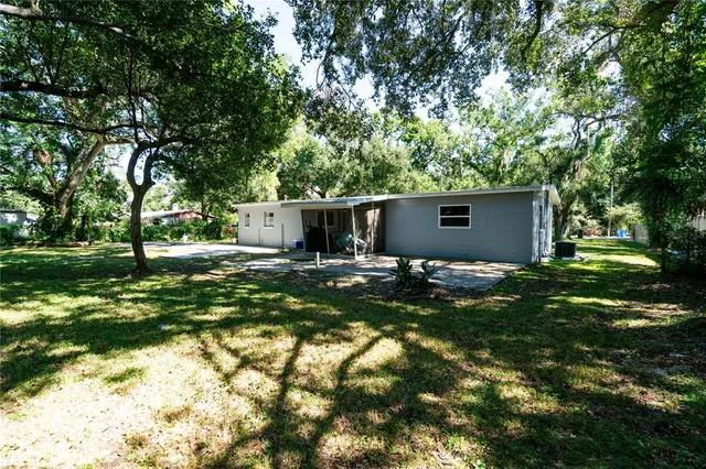 a view of a house with backyard and trees