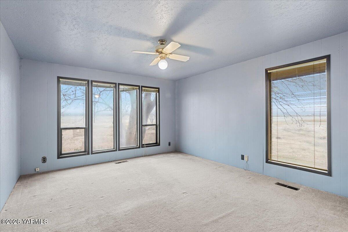1861 North Cottonwood Road Yakima, WA 98908 - Photo 17 of 35 an empty room with chandelier fan and windows