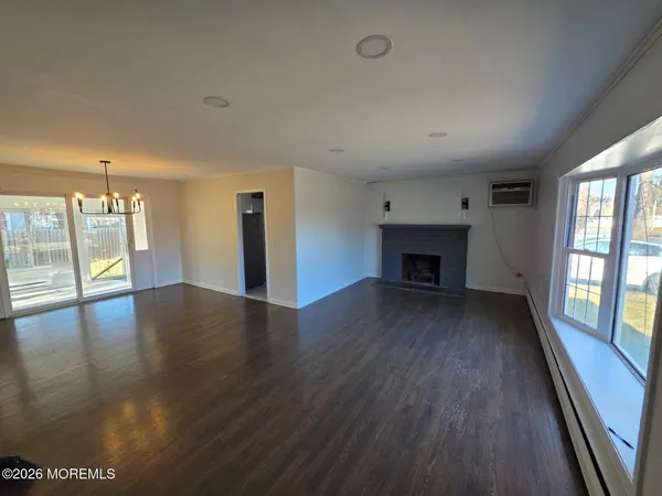 an empty room with wooden floor and a fireplace
