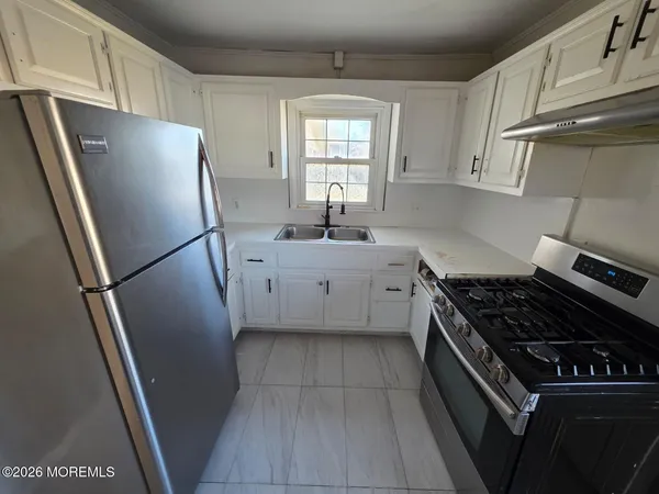 a kitchen with a refrigerator a sink and cabinets