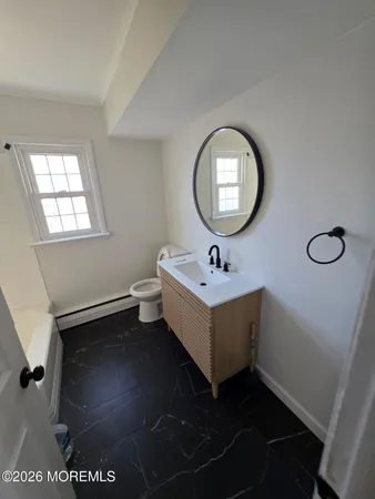 a bathroom with a sink mirror and toilet