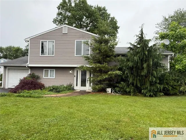 a front view of a house with a yard and trees