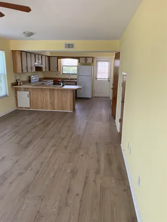 a view of a kitchen with a sink microwave and cabinets