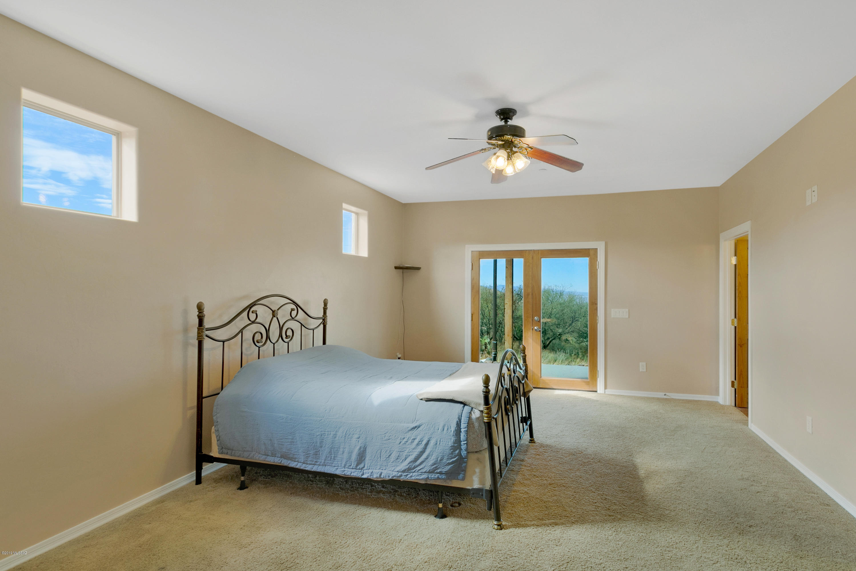 21960 South Helvetia Road Sahuarita, AZ 85629 - Photo 19 of 29 a bedroom with a bed and a chandelier