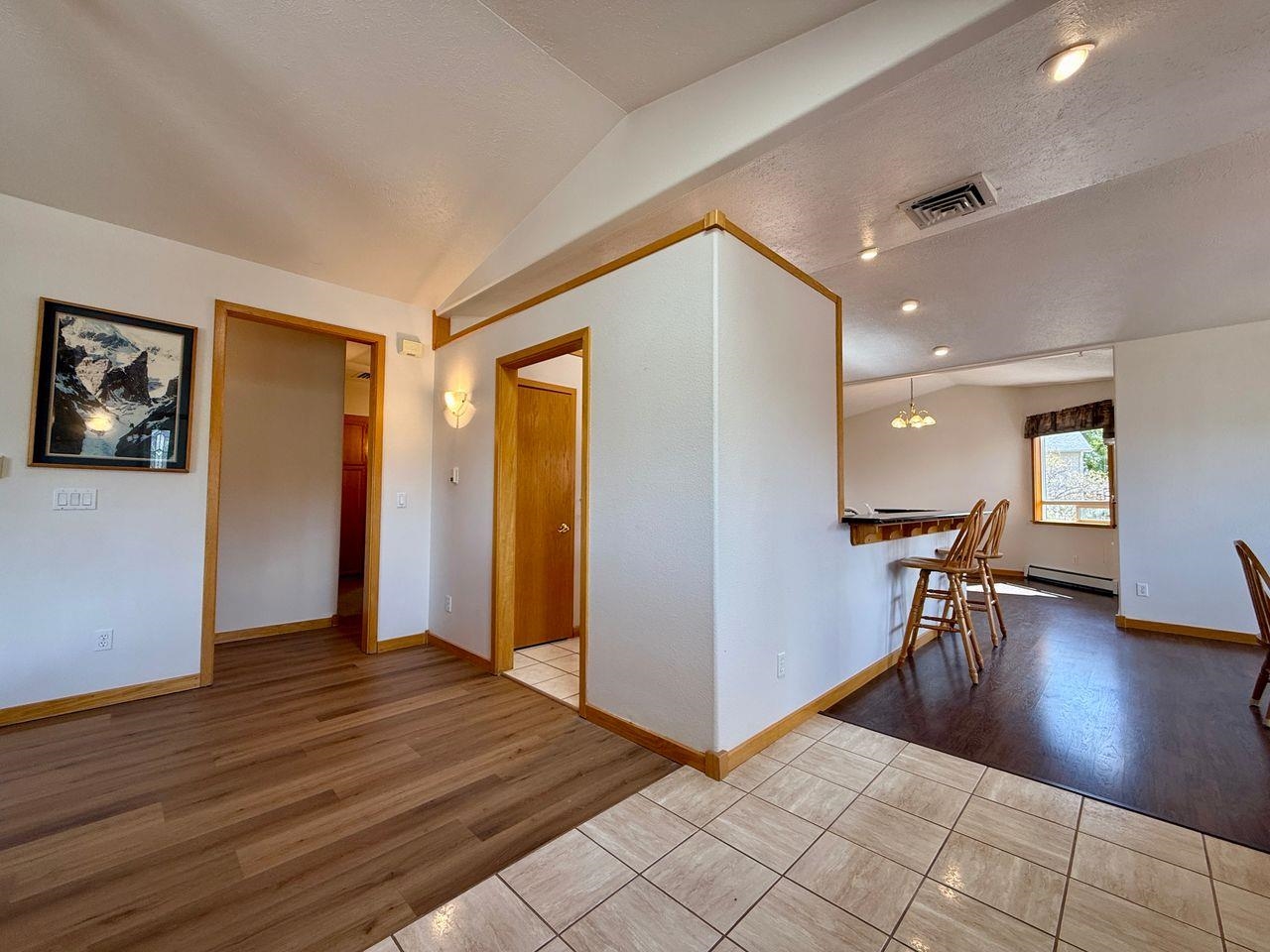 920 Crown Court Fruita, CO 81521 - Photo 11 of 42 a view of a hallway with wooden floor and a living room