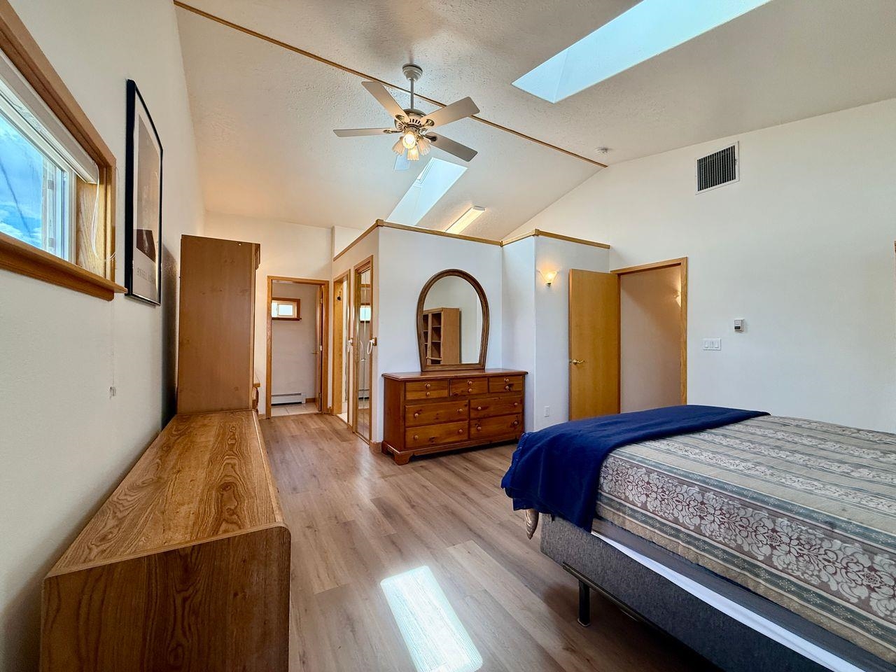 920 Crown Court Fruita, CO 81521 - Photo 17 of 42 a bedroom with a bed and a dresser with wooden floor