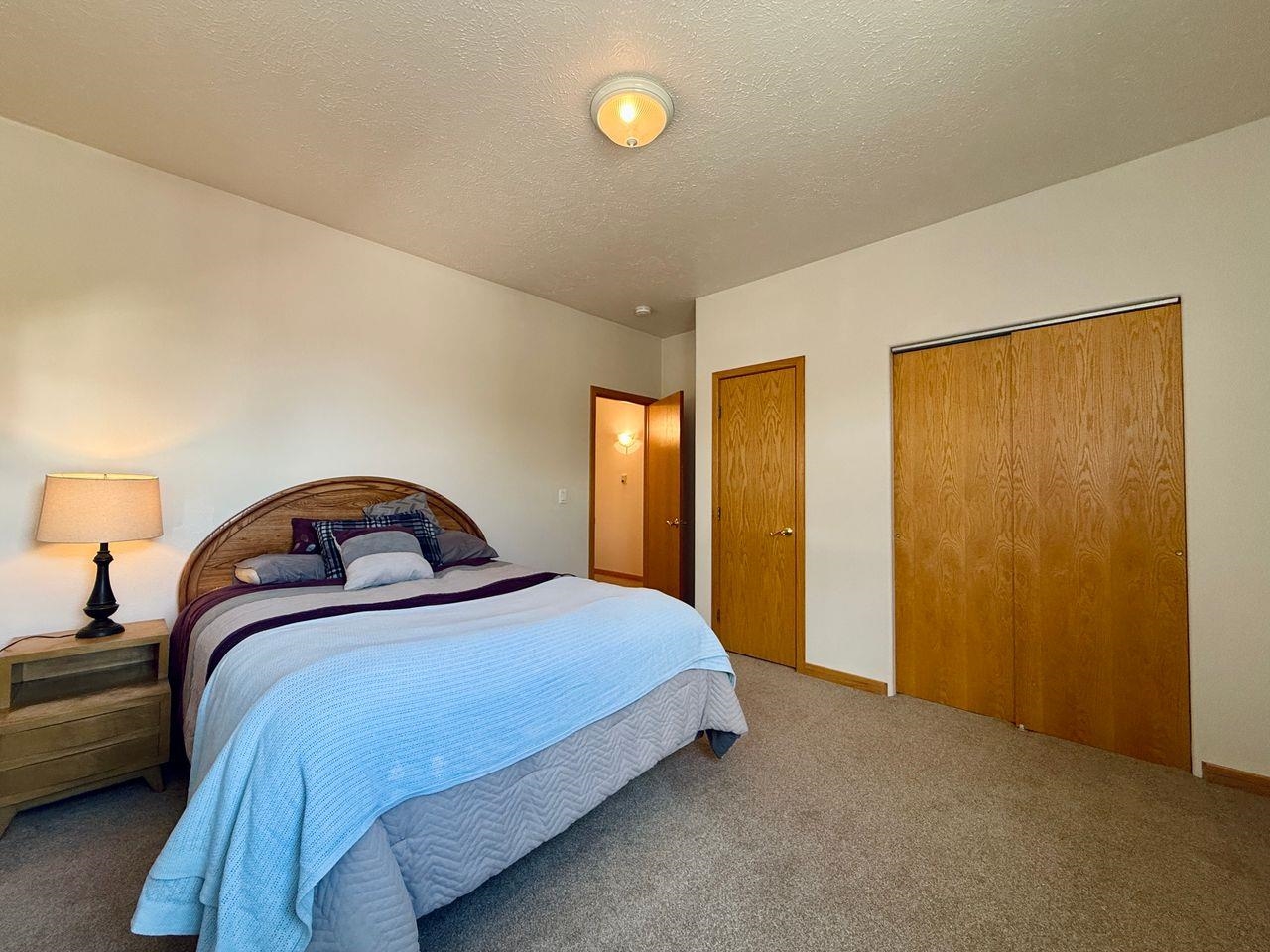 920 Crown Court Fruita, CO 81521 - Photo 22 of 42 a bedroom with a bed and lamp