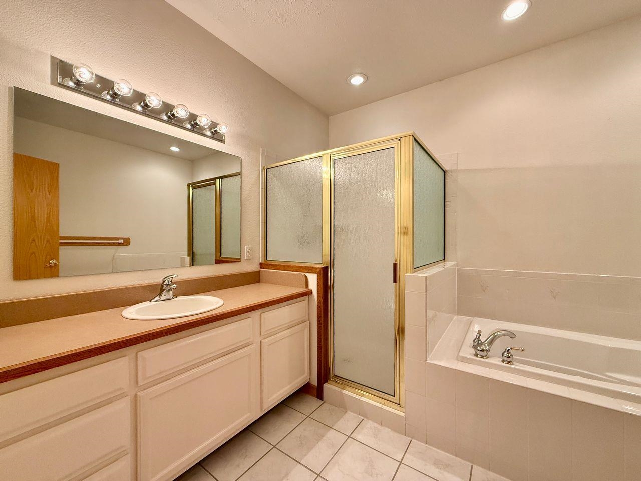 920 Crown Court Fruita, CO 81521 - Photo 25 of 42 a spacious bathroom with a double vanity sink a mirror and a shower