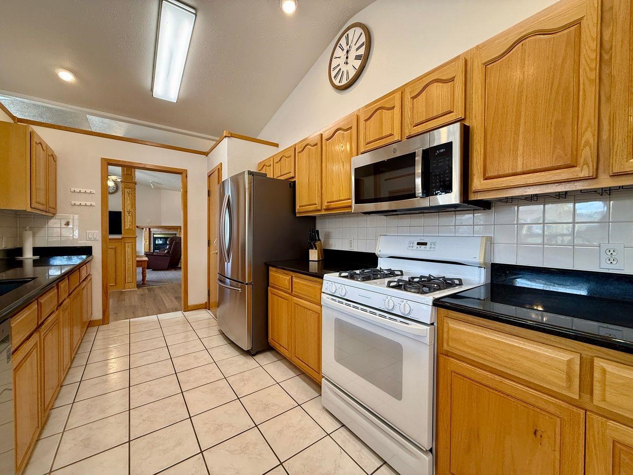 920 Crown Court Fruita, CO 81521 - Photo 4 of 42 a kitchen with stainless steel appliances granite countertop a stove a refrigerator and a microwave