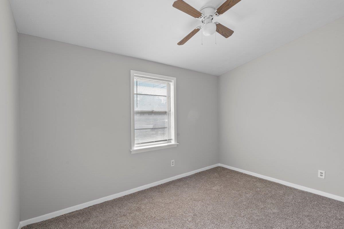 4948 Knight Arnold Road Memphis, TN 38118 - Photo 11 of 27 Carpeted empty room featuring baseboards and ceiling fan