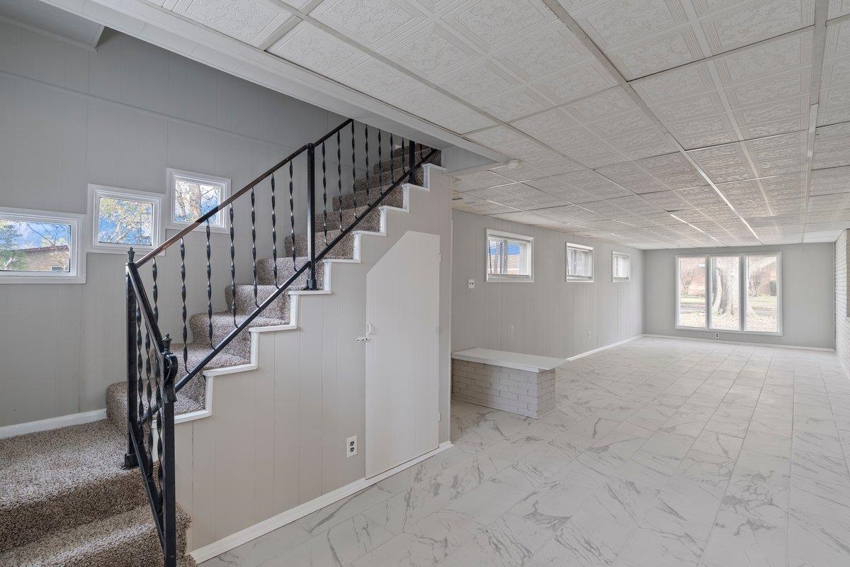 4948 Knight Arnold Road Memphis, TN 38118 - Photo 14 of 27 Staircase featuring wooden walls and marble finish floors