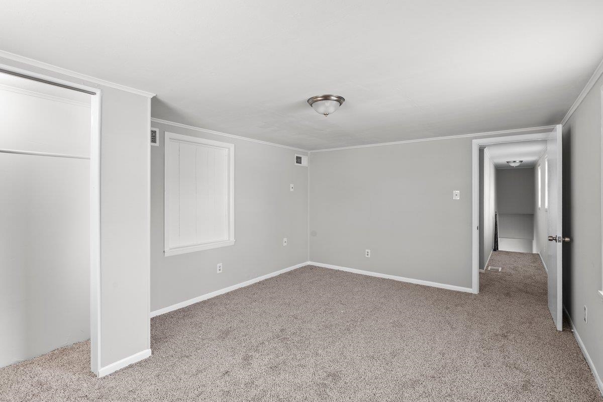 4948 Knight Arnold Road Memphis, TN 38118 - Photo 19 of 27 Unfurnished bedroom featuring light colored carpet and crown molding