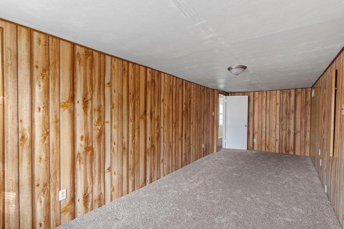 4948 Knight Arnold Road Memphis, TN 38118 - Photo 21 of 27 Unfurnished room with carpet flooring and wooden walls