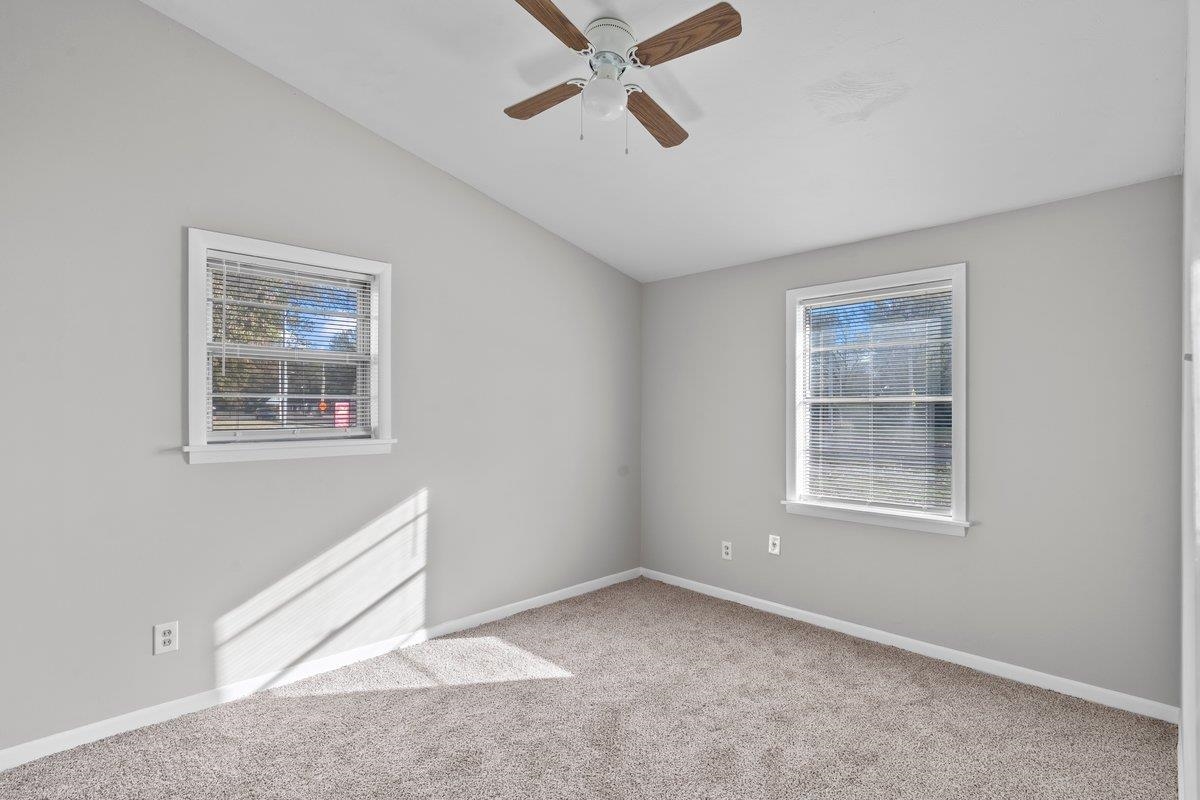 4948 Knight Arnold Road Memphis, TN 38118 - Photo 6 of 27 Spare room featuring lofted ceiling, light carpet, healthy amount of natural light, and a ceiling fan