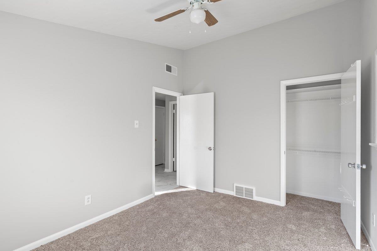 4948 Knight Arnold Road Memphis, TN 38118 - Photo 10 of 27 Unfurnished bedroom featuring vaulted ceiling, light colored carpet, a closet, and a ceiling fan