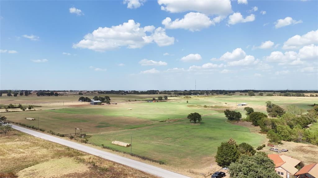 2101 Billings Road Tolar, TX 76476 - Photo 20 of 23 Expansive rural acreage featuring green pastures, scattered mature trees, and a paved road