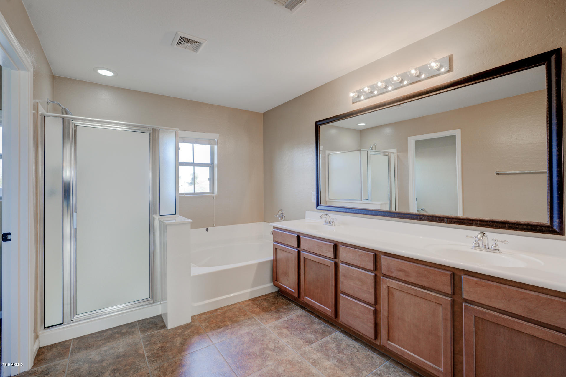 1891 South Racine Lane Gilbert, AZ 85295 - Photo 16 of 35 a spacious bathroom with a tub sink and mirror