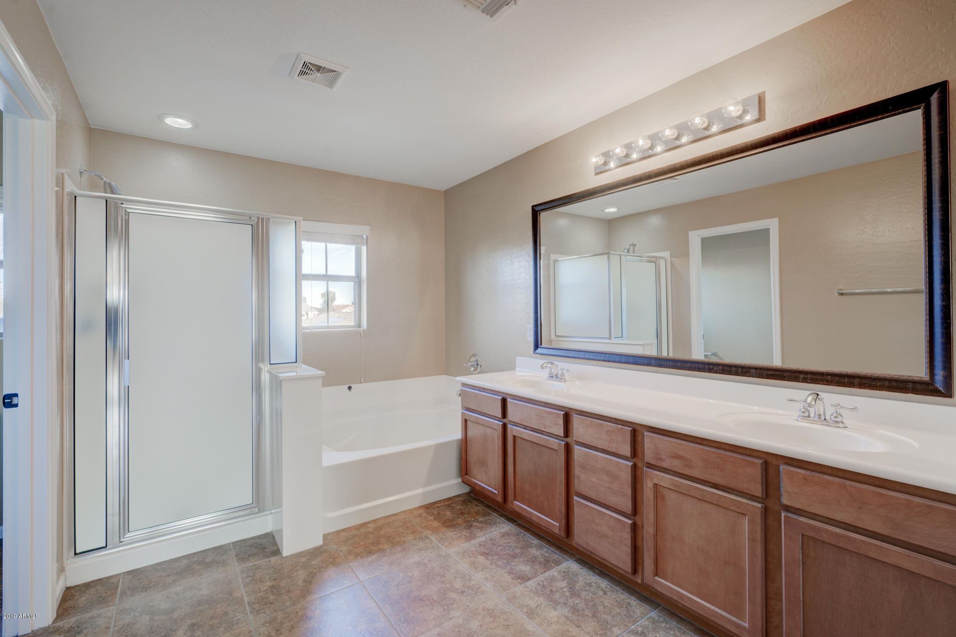 1891 South Racine Lane Gilbert, AZ 85295 - Photo 17 of 35 a spacious bathroom with a tub sink and mirror