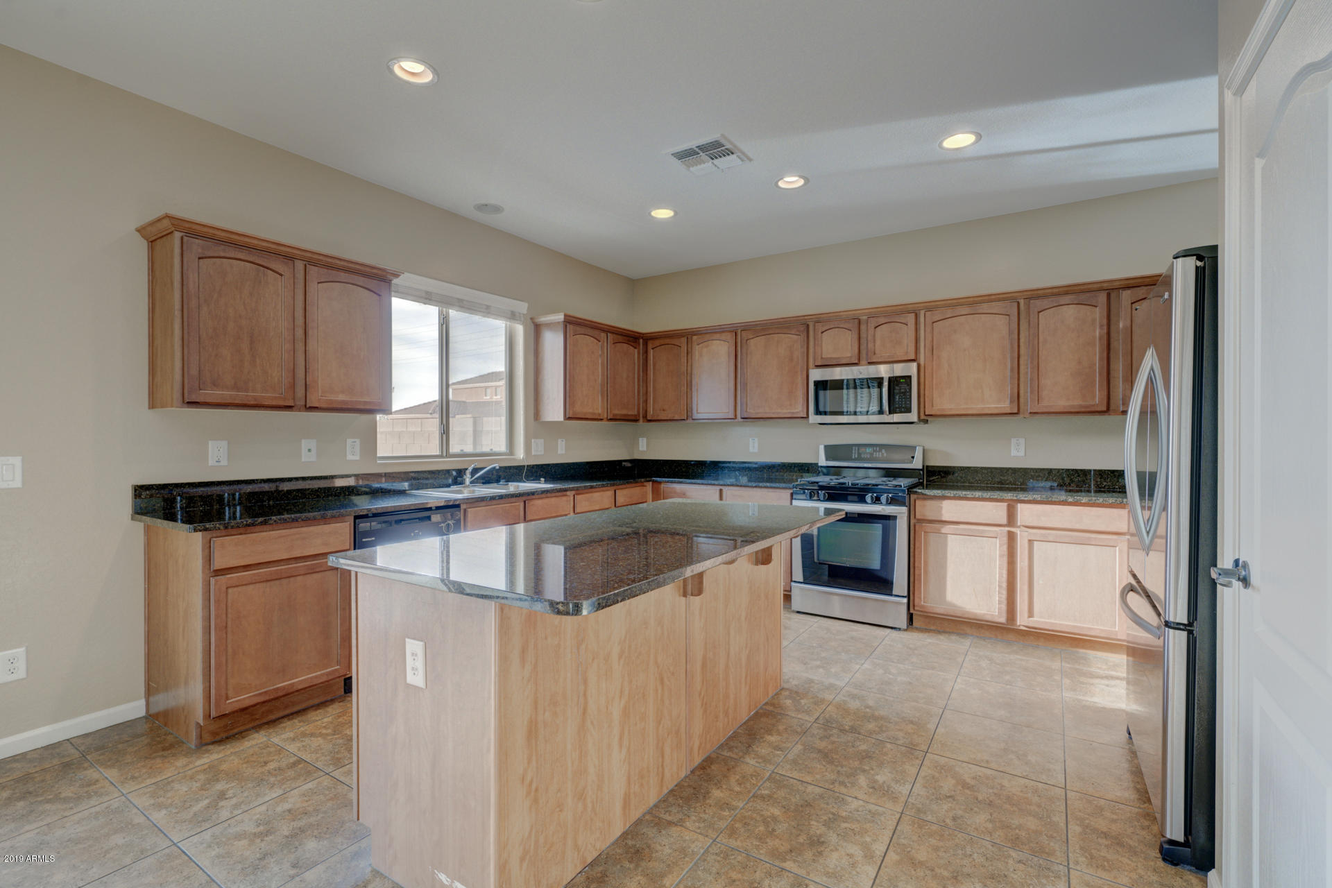 1891 South Racine Lane Gilbert, AZ 85295 - Photo 6 of 35 a kitchen with stainless steel appliances granite countertop a sink and a stove