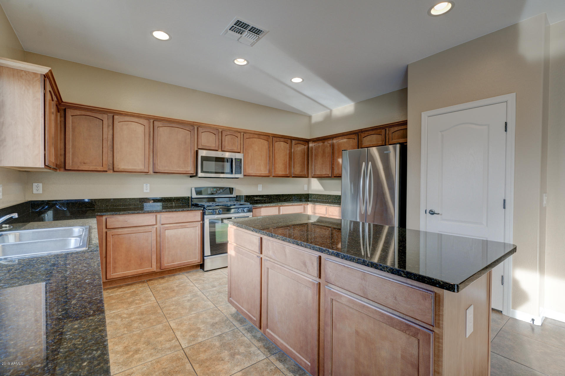 1891 South Racine Lane Gilbert, AZ 85295 - Photo 7 of 35 a kitchen with kitchen island granite countertop a sink counter top space appliances and cabinets