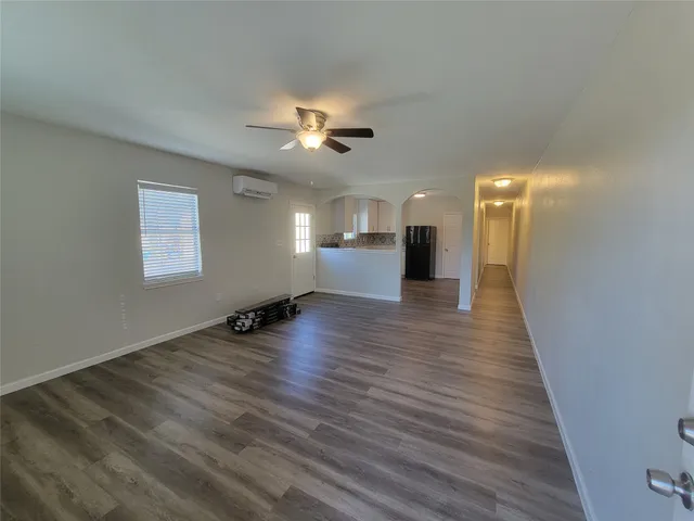 a view of empty room with wooden floor and ceiling fan