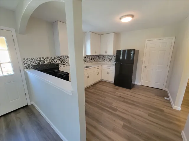 a kitchen with a refrigerator and a stove top oven