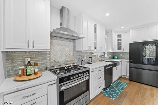 a kitchen with stainless steel appliances granite countertop a stove a sink and a refrigerator