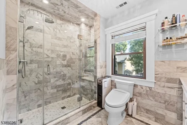 a bathroom with a granite countertop toilet a sink and a shower