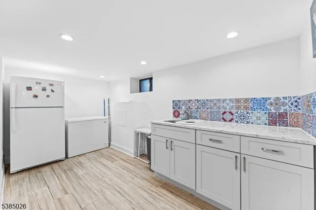 a kitchen with white cabinets and refrigerator
