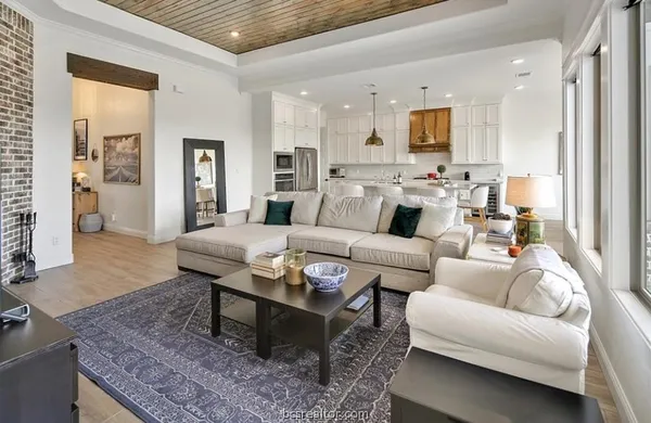 a living room with furniture potted plant and kitchen view