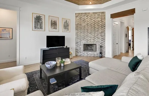 a living room with furniture a flat screen tv and a fireplace