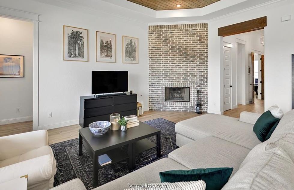 5013 Greenstone Way Bryan, TX 77802 - Photo 3 of 11 a living room with furniture a flat screen tv and a fireplace