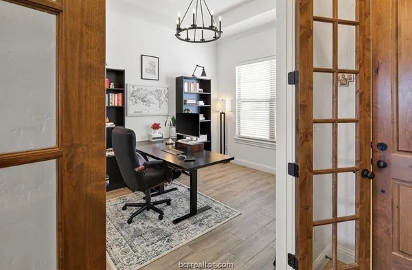 a view of a workspace with furniture and a window