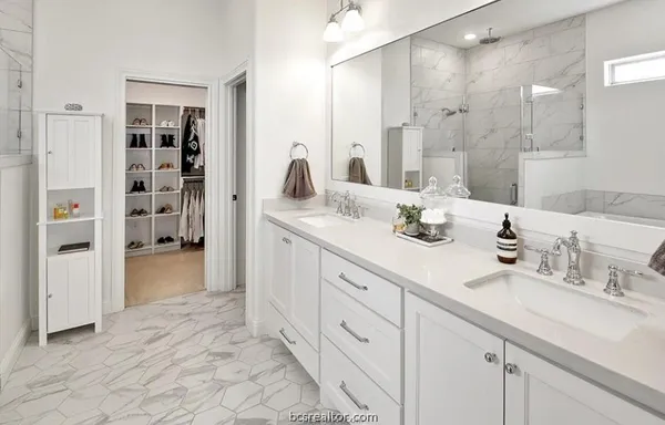 a spacious bathroom with a double vanity sink mirror and double