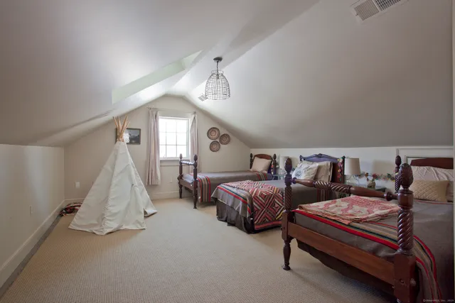 a spacious bedroom with two beds and window