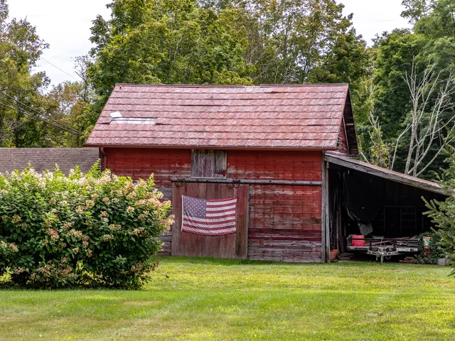 a backyard of a house with barbeque oven and trees