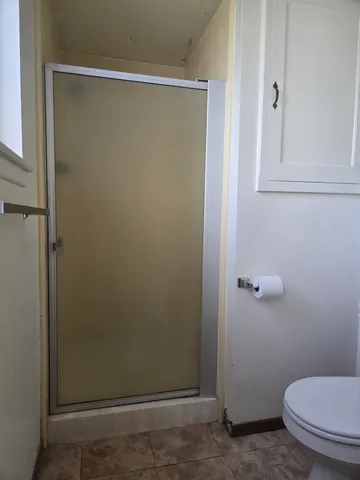 a bathroom with a toilet and a shower