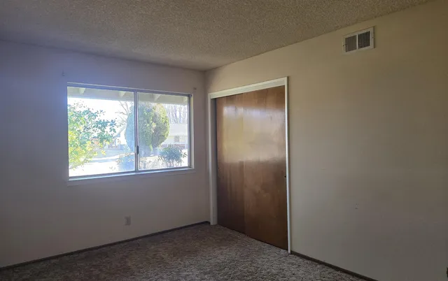an empty room with windows and closet