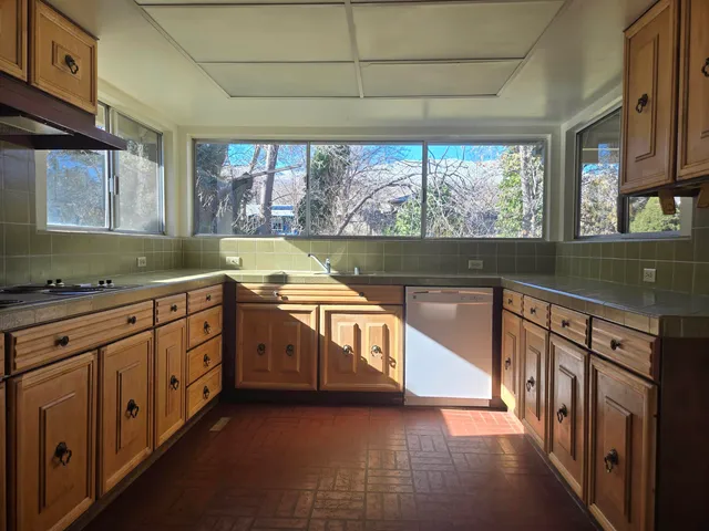 a kitchen with stainless steel appliances a sink and a large window