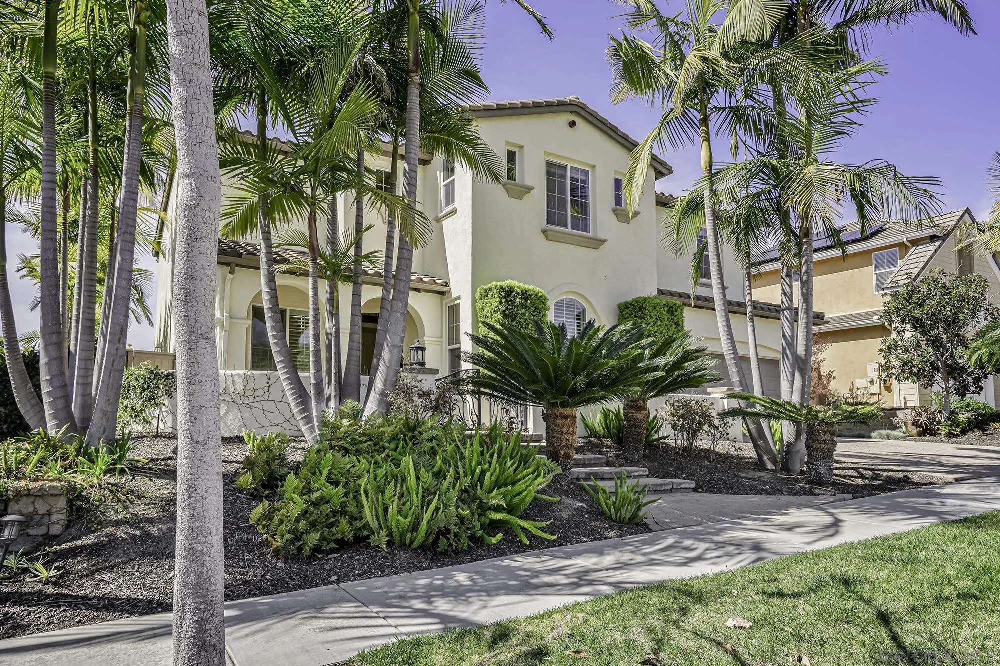 7065 Crystalline Drive Carlsbad, CA 92011 - Photo 1 of 26 a front view of a house with a garden