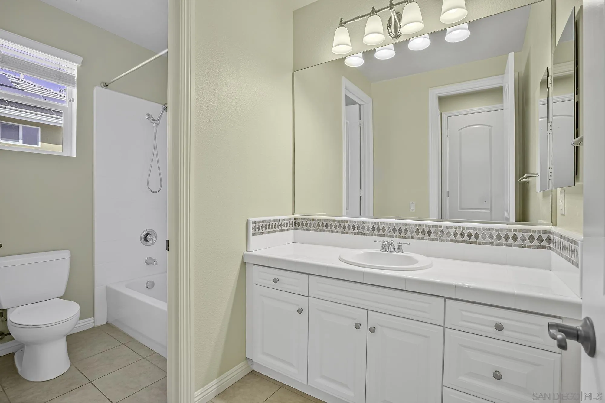 7065 Crystalline Drive Carlsbad, CA 92011 - Photo 18 of 26 a bathroom with a sink a toilet and a large mirror