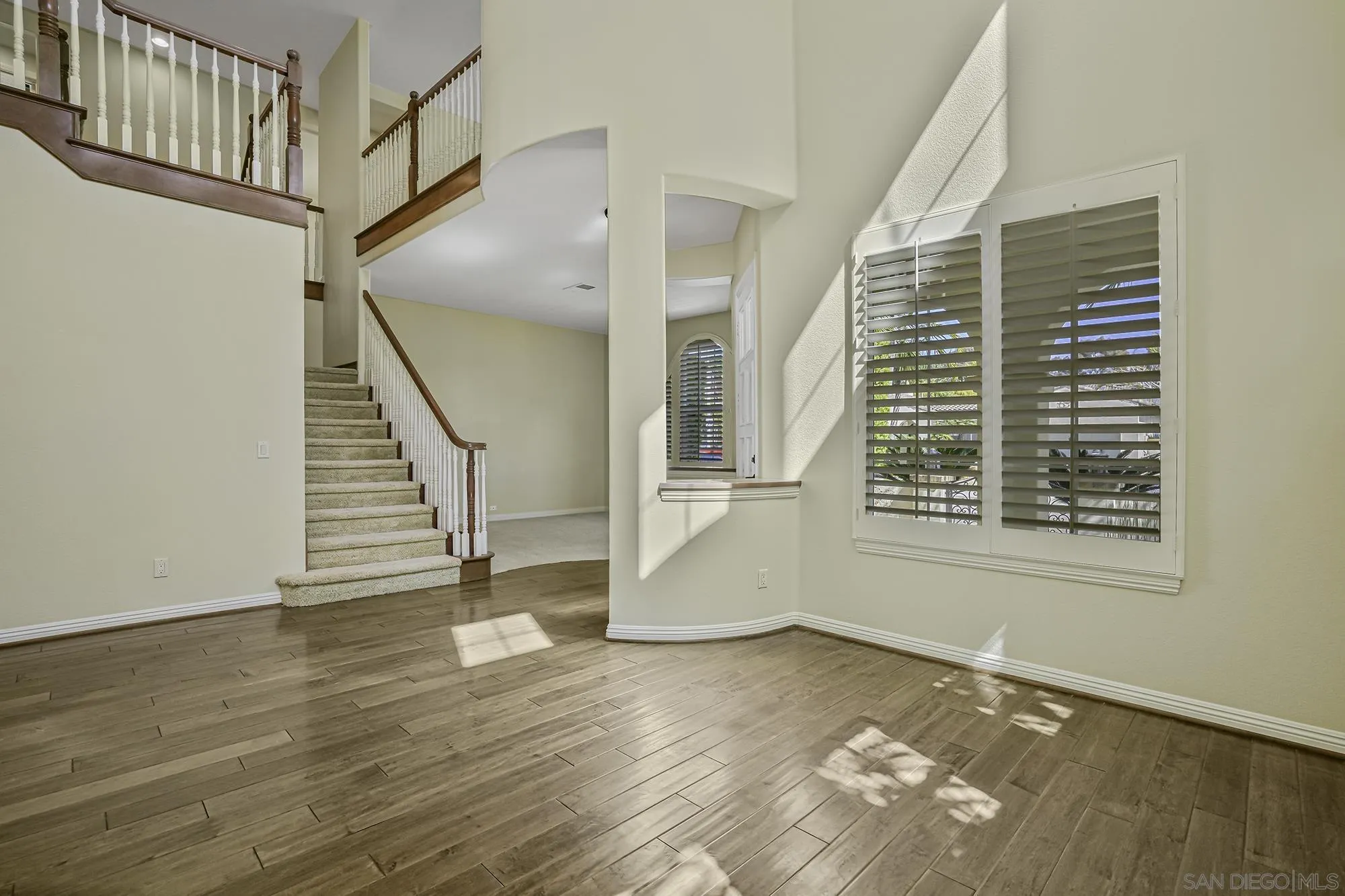 7065 Crystalline Drive Carlsbad, CA 92011 - Photo 4 of 26 a view of an entryway with wooden floor and stairs