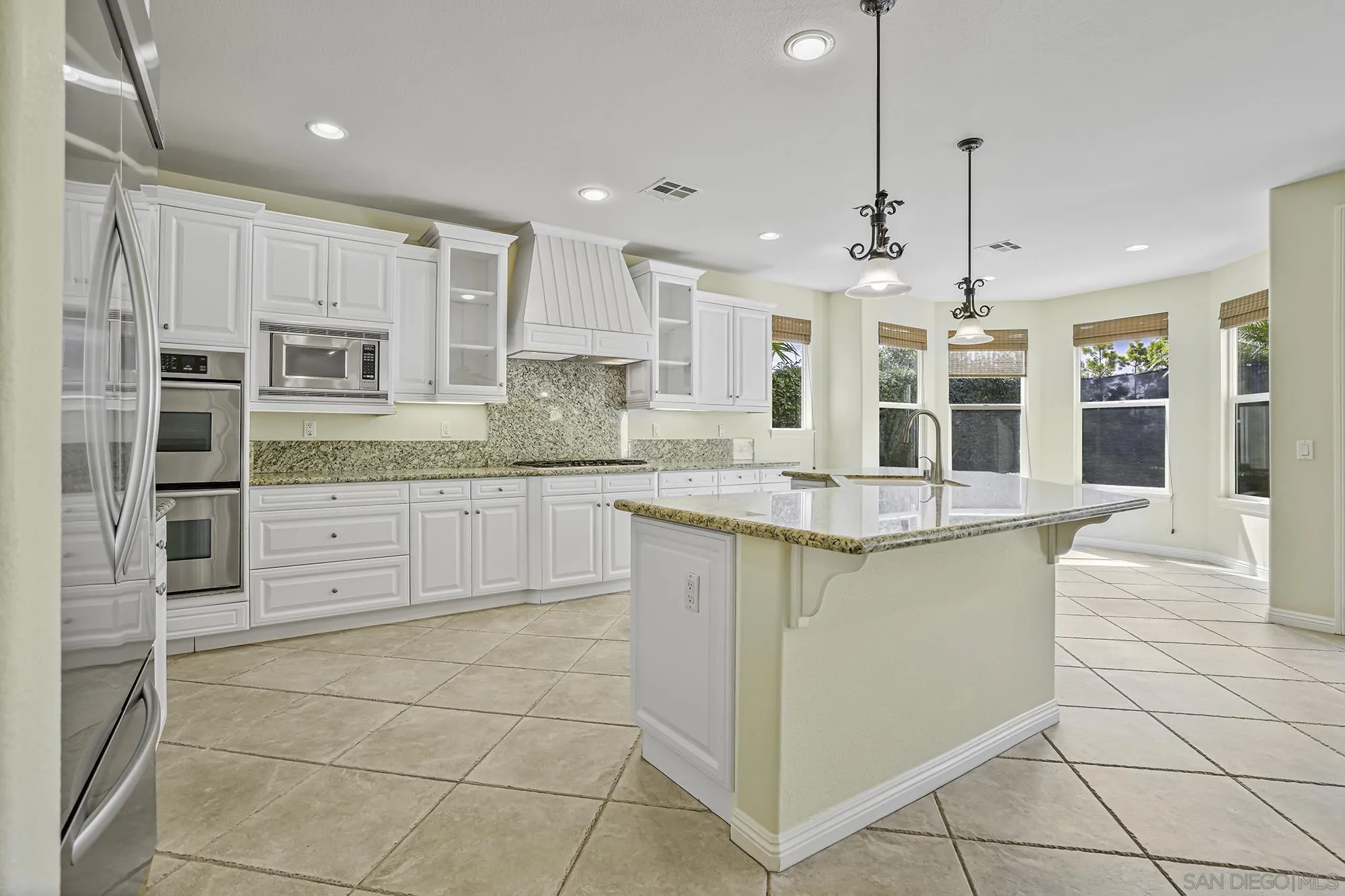 7065 Crystalline Drive Carlsbad, CA 92011 - Photo 7 of 26 a kitchen with stainless steel appliances granite countertop a sink and a refrigerator