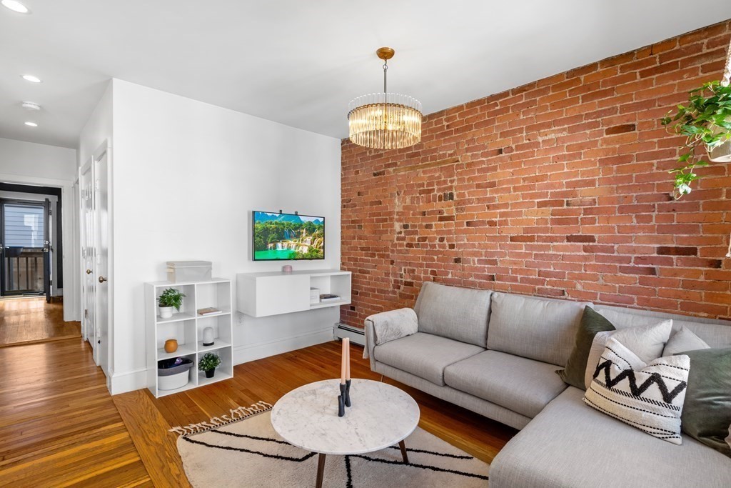217 Boylston Street, Unit 3 Boston, MA 02130 - Photo 11 of 18 a living room with patio furniture and a wooden floor