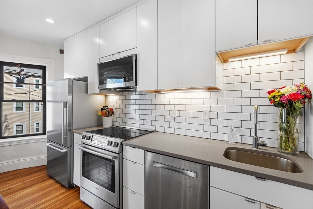 217 Boylston Street, Unit 3 Boston, MA 02130 - Photo 5 of 18 a kitchen with stainless steel appliances a sink a stove and cabinets
