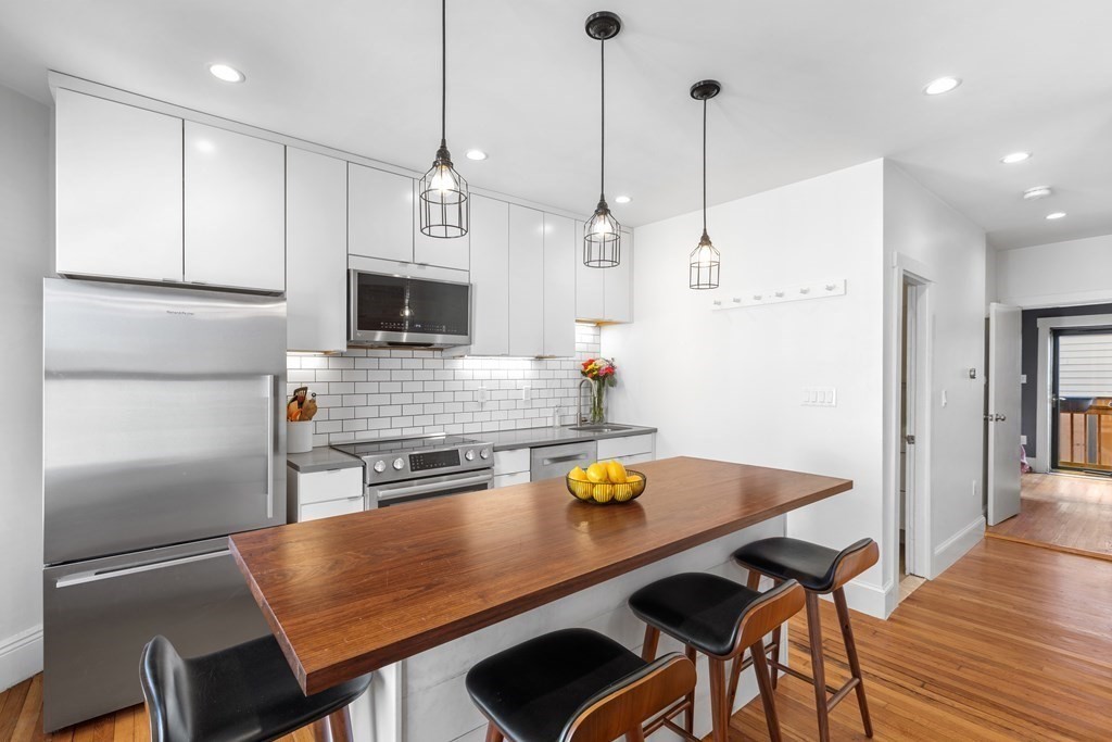 217 Boylston Street, Unit 3 Boston, MA 02130 - Photo 6 of 18 a kitchen with a table chairs and refrigerator